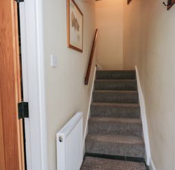 A staircase with a handrail and framed picture at Rose Cottage Broughton-In-Furness