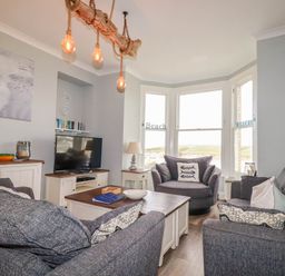 A living room with sofas and a television at Seashore House in Porth