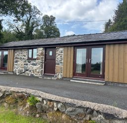 An exterior view of a building with stone and wood features at Bothi in Llanuwchllyn