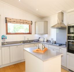 A kitchen with grey countertops a central island stainless steel oven and microwave at Brooke in Exton Rutland