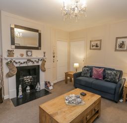 A living room with a fireplace sofa coffee table and wall art at Robins Nest in Whitby