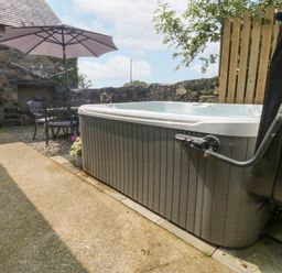 An outdoor space featuring a hot tub and seating area at Cegin Foch in Chwilog