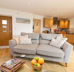 A living room with a sofa and fruit bowl at Cawsand in Tideford