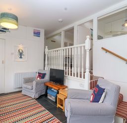 A living room with armchairs and a television at 2 Brook Cottages Hope Cove