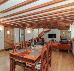 A living room with a dining table and sofa at Penrhiwarwydd Barn in Pontywaun