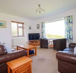 A living room with a television and sofa at Pentreath in Crantock
