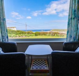 A living room with a view of the ocean at Pentreath in Crantock