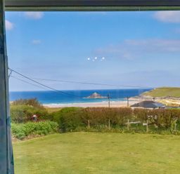 A view of the ocean and beach from a window at Pentreath in Crantock