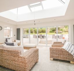 A sitting room with wicker sofas and a skylight at The Orchard in Crantock