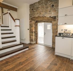 An entryway with a staircase and kitchen cabinets at The Turnip Barn in 