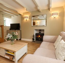 A living room with a sofa and television at Tan Y Goeden in Morfa Nefyn
