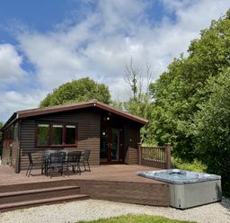 A cabin with a deck and hot tub at Willow Lodge in Constantine near Falmouth
