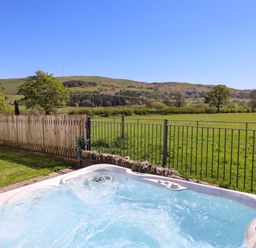 An outdoor area with a hot tub and view of the countryside at Cefn Nannau near Ty-nant Cerrigydrudion