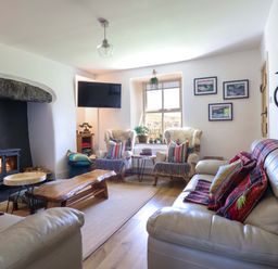 A living room with a fireplace and seating area at Cefn Nannau near Ty-nant Cerrigydrudion