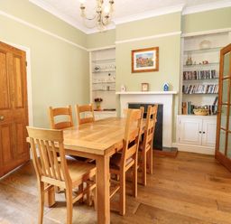 A dining room with a wooden table and chairs at Tilly's Retreat in Hunstanton