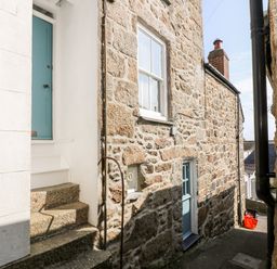 A narrow stone alleyway with two blue doors and stone steps at Mole Cottage in Mousehole