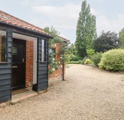 An entrance with a gravel path and a rose bush at Lowbrook Cottage Dickleburgh near Diss