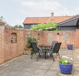 An outdoor patio with a table and chairs at Lowbrook Cottage in Dickleburgh near Diss