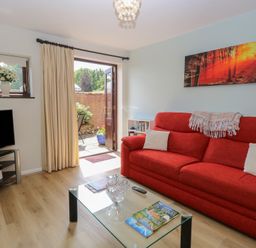 A living room with a sofa and coffee table at Lowbrook Cottage in Dickleburgh near Diss