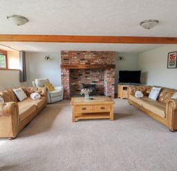 A living room with a fireplace and sofas at Glanyrafon in St Harmon