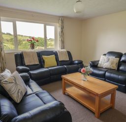 A living room with sofas and a coffee table at Glanyrafon Bungalow St Harmon