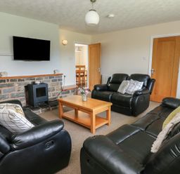 A living room with a sofa and coffee table at Glanyrafon Bungalow in St Harmon
