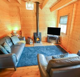 A living room with a fireplace and sofa at Tythe Lodge – Hot Tub Retreat in Rural Lincolnshire | Family-Friendly Lodge Near Heckington