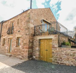 Stone building with balcony and outdoor furniture at Apple Tree Cottage in Bleatarn near Kirkby Stephen