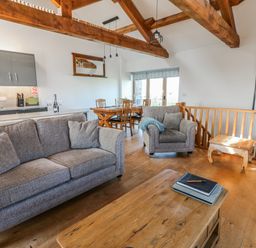 A living room with a sofa and dining area at Apple Tree Cottage Bleatarn near Kirkby Stephen