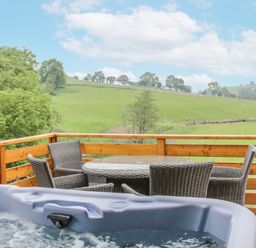 A balcony with a hot tub and outdoor furniture at Manor Farm Lodges - Red Kite Lodge in Newtown