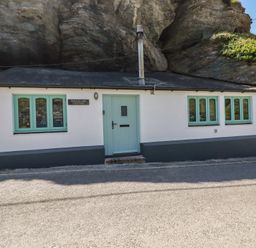A cottage with a blue door and windows at Smugglers Cottage Trebarwith Strand near Tintagel