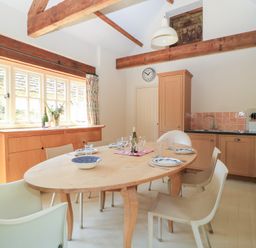 A dining room with a table and chairs at Upper Mill Barn in Coln St Aldwyns, near Bibury