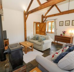 A living room with a sofa and coffee table at Robbie's Barn Fulready near Stratford-upon-Avon