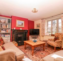 A living room with a bookshelf and fireplace at Elm View in Chipping Campden