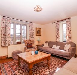 A living room with a sofa, coffee table, and television at Elm View in Chipping Campden