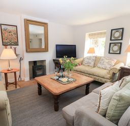 A living room with a coffee table and television at Fairview Cottage in Milton-Under-Wychwood