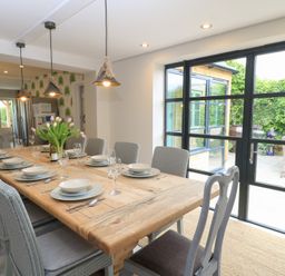 A dining room with a table set for a meal at Fairview Cottage in Milton-Under-Wychwood