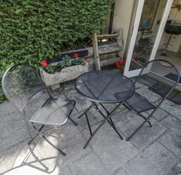 A table and chairs on a stone patio at The Old Reading Room in Bledington near Stow-on-the-Wold