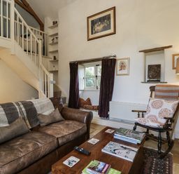 A living room with a sofa and coffee table at The Old Reading Room in Bledington near Stow-on-the-Wold