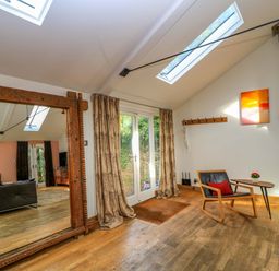 A living room featuring a mirror and sofa at The Linhay in Little Coxwell near Faringdon