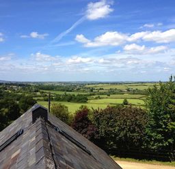 A rural landscape with fields trees and a roof in the foreground at Stepwell in Moreton-In-Marsh