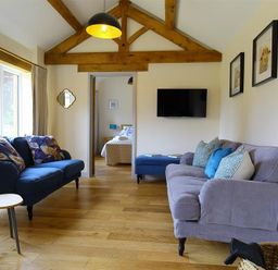 A living room with two sofas pillows wooden floor and exposed ceiling beams at Park Stables Wyck Beacon near Bourton-on-the-Water
