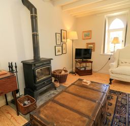 A living room with a stove and television at Cider Press Cottage Priston Village, Bath