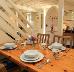 A dining room with a table set for meals at Cider Press Cottage in Priston Village, Bath