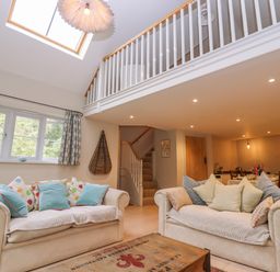 A living room with two sofas and a wooden coffee table under a skylight at Bridge Studio in Broad Chalke