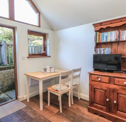 A dining room with a table and chairs at Pop's Barn in Downton