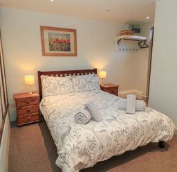 A bedroom with a bed and nightstands at Pop's Barn in Downton