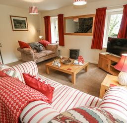 A living room with a sofa and television at Droop Farm Cottage in Droop near Hazelbury Bryan