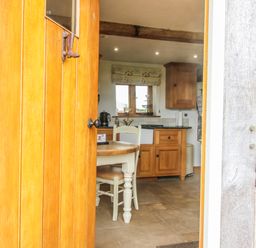 A kitchen with a table and chairs visible from the doorway at The Shooting Folly in Cheswardine