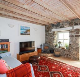 A living room with a sofa and television at Greeb Rocks Cottage in Marazion
